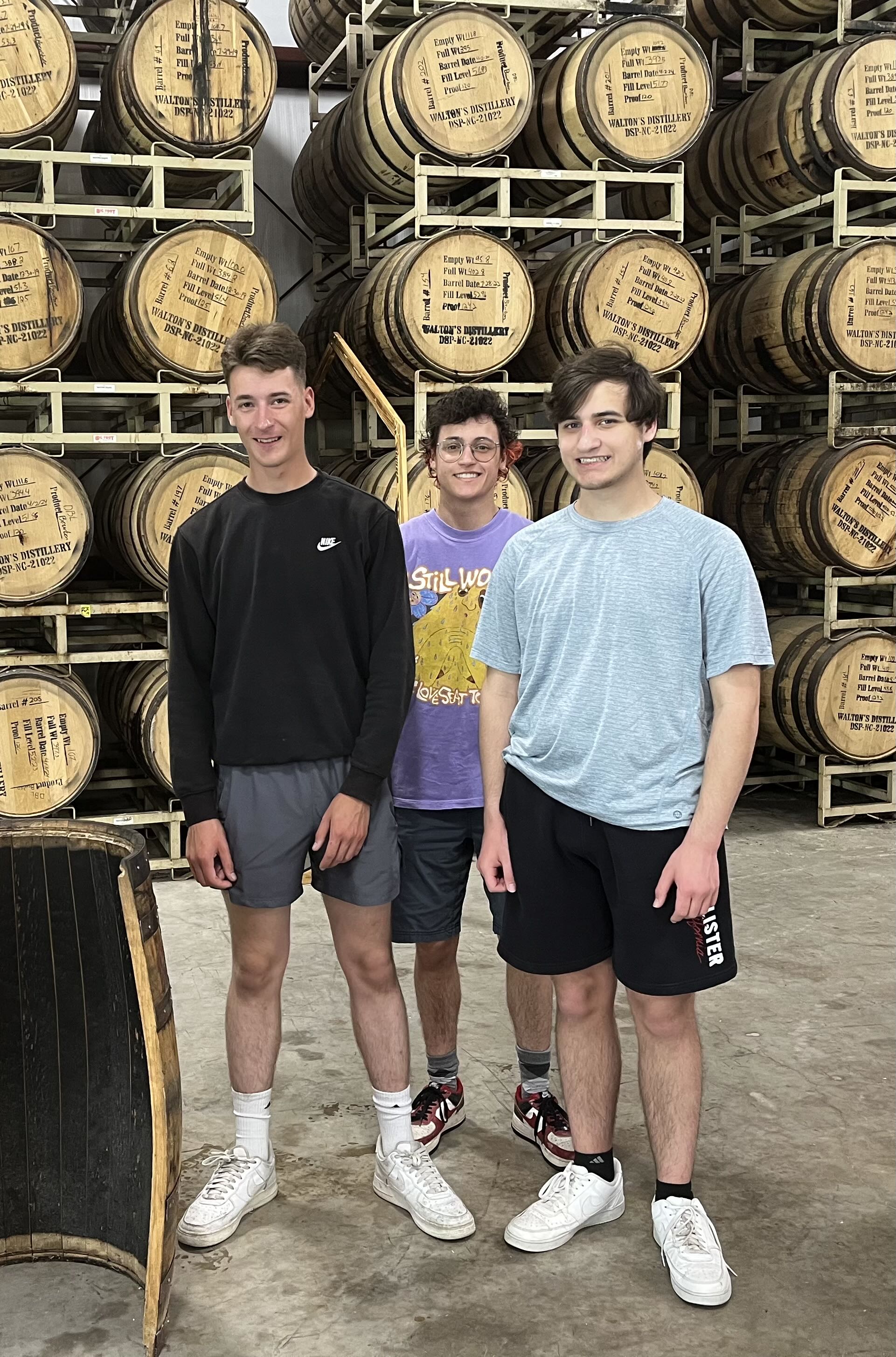 Nick, Max, and Drew in a barrel aging room at a distillery in North Carolina.